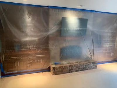 Layered metal wall panels with geometric patterns and brick base accent