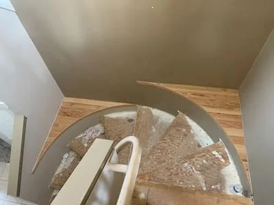 Hardwood flooring installation with wood planks and cutting tools on subfloor