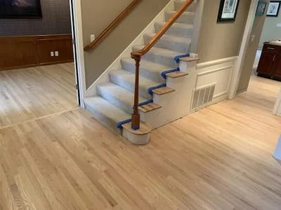 Luxury vinyl plank flooring installation with matching stair treads and protective coverings
