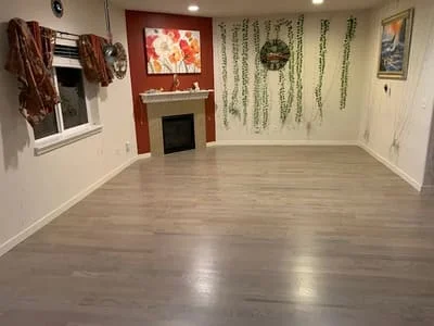 Laminate flooring installation in basement with warm wood-tone finish and polished surface