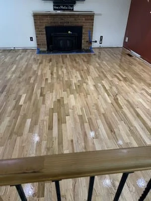 Newly installed and finished hardwood flooring with mixed-width planks in natural tone